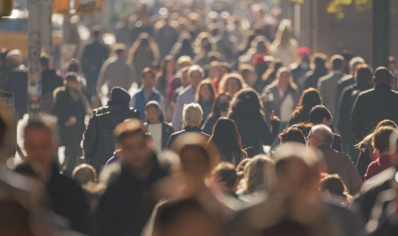 una multitud de personas caminando por una calle concurrida